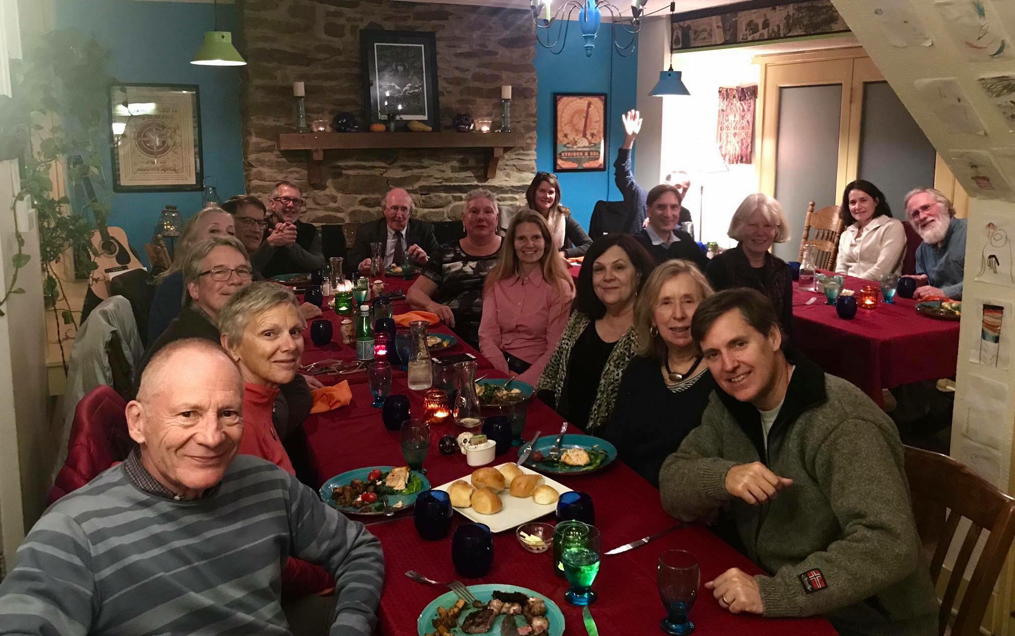 People seated around a long table enjoying . party at the Canal House